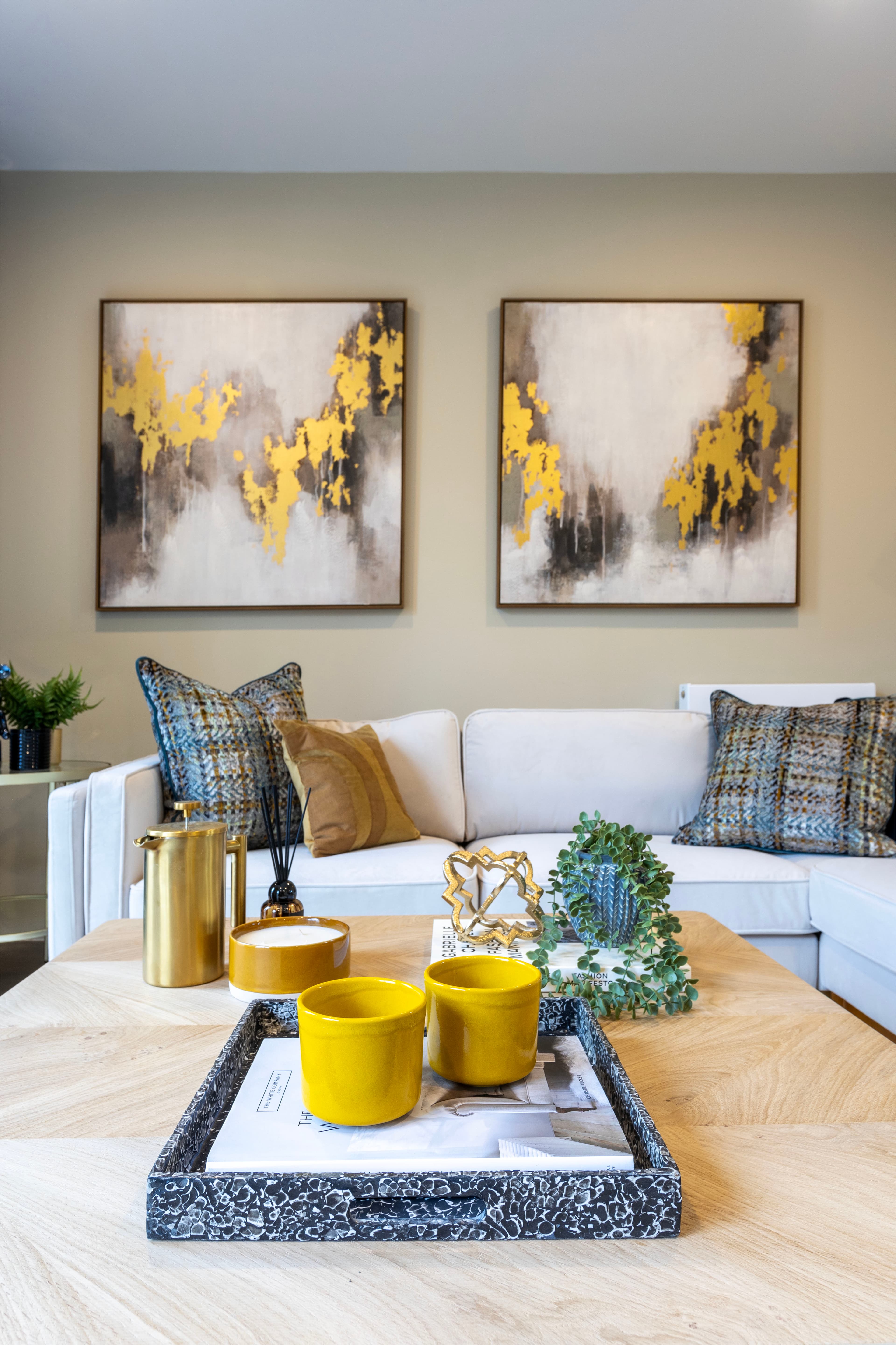A modern designed living room with artwork on the walls and a sofa by Focus Agency Group at the Garratt Collection